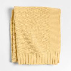 a yellow knitted blanket on a white background