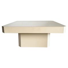 a white table with a square shaped top and two smaller rectangular bases on the side