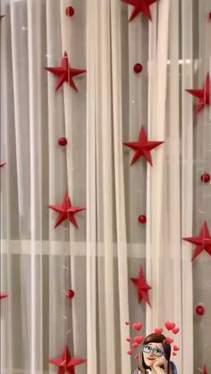 a doll sitting in front of a curtain with red stars on it