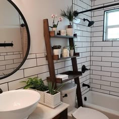 a white toilet sitting next to a bath tub under a bathroom mirror above a sink