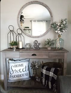 a wooden table topped with a mirror and pillows