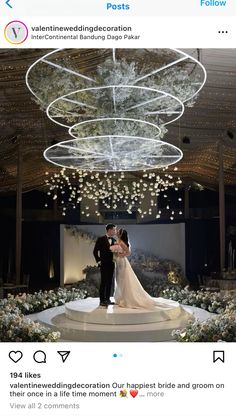 the bride and groom are standing in front of an elaborate chandelier at their wedding