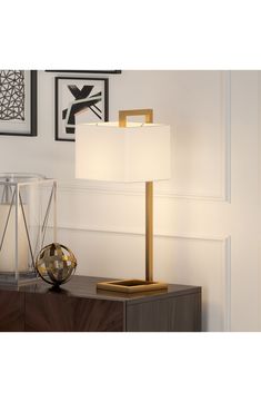 a lamp that is sitting on top of a wooden table next to a glass container