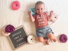 a baby is laying on the bed with doughnuts