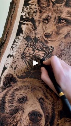 a person is drawing on a piece of wood