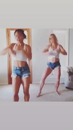 two women in short shorts are dancing together