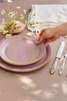 a table with plates, utensils and flowers on it is set for two