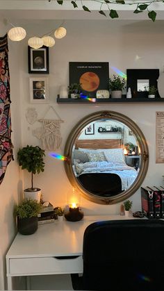 a bedroom with a desk, mirror and plants on the wall above it is lit by candles