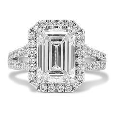 an emerald - cut diamond ring with double halos and pave diamonds on the band