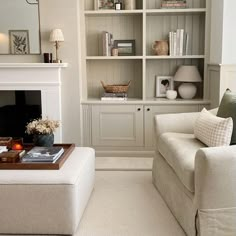 a living room filled with furniture and a fire place in the middle of it's walls