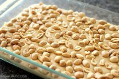 a glass baking dish filled with peanut butter and cashews, ready to go into the oven