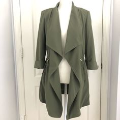 3/4 Sleeve Jacket Adjustable String To Enhance And Flatter Your Waist Line, Gold Metal To Hold On Place String. Very Classic Long Coat, Blazer Style With Drape Effect In The Front. Pockets On Both Sides. Neutral Olive Color, To Wear All Year Round. Mannequin Has Size Small On. Brand New Green Open Front Outerwear For Spring, Khaki Spring Outerwear For Office, Spring Khaki Outerwear For Office, Spring Layering Outerwear With 3/4 Sleeve, Fitted Olive Long Sleeve Outerwear, Olive Long Sleeve Outerwear For Work, Olive Fitted Long Sleeve Outerwear, Fall Outerwear With Pockets And 3/4 Sleeve, Green Open Front Outerwear For Layering