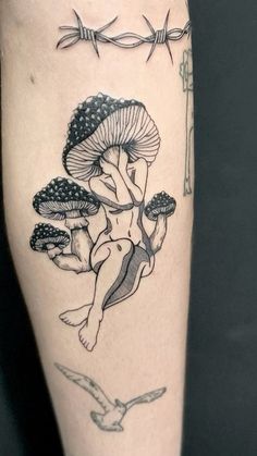 a woman with mushrooms on her leg and barbed wire around her ankles is depicted in this tattoo design