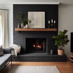 a living room with a fire place, couch and television on the wall in front of it