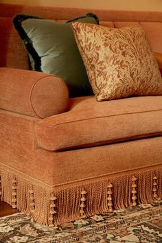 an orange couch with pillows on top of it