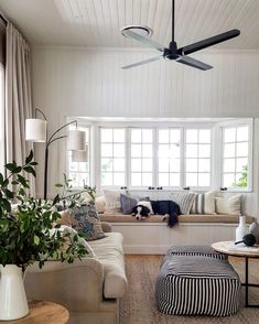 a living room filled with furniture and a ceiling fan in the middle of the room