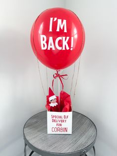 a red balloon with the words i'm back on it sitting on top of a table