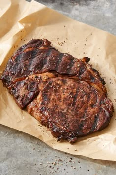 two pieces of meat sitting on top of brown paper