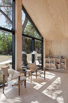 a living room filled with furniture and lots of windows next to a wooden floored wall