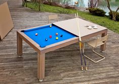 a pool table on a deck with chairs around it