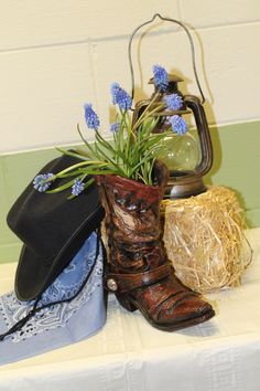 a pair of cowboy boots and hat sitting on top of a table