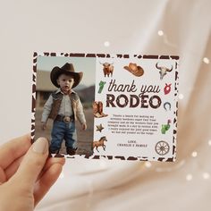 a person holding up a card with an image of a little boy wearing a cowboy hat