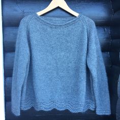 a blue sweater hanging on a wooden hanger