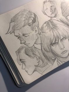 an open book with drawings of people on the pages and one man's head