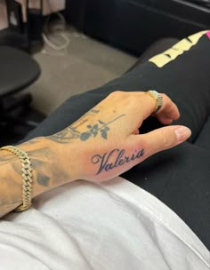 a person with a tattoo on their left hand and the word valeris written in blue ink