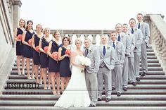 a bride and groom with their wedding party on the steps