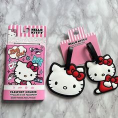 two hello kitty luggage tags are shown next to each other on a marble countertop