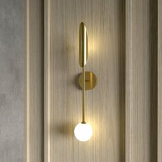 a wall light that is on the side of a door with wood paneling behind it