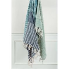 two towels hanging on a hook in front of a white door with a blue and green striped towel