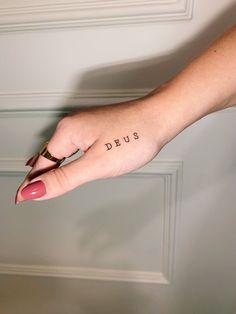 a woman's hand with the word deus tattooed on it