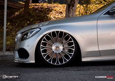 the front end of a silver car with chrome rims