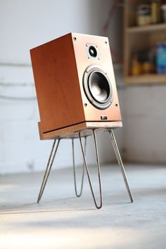 a wooden speaker sitting on top of a metal stand