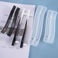 three pieces of black and white hair clips sitting on top of a piece of paper