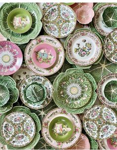 many plates are stacked on top of each other in different colors and designs, including green