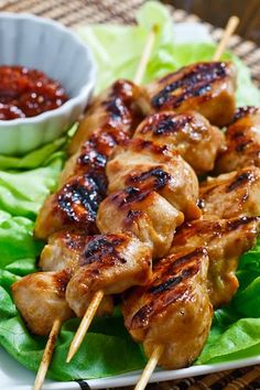 chicken skewers on lettuce with dipping sauce