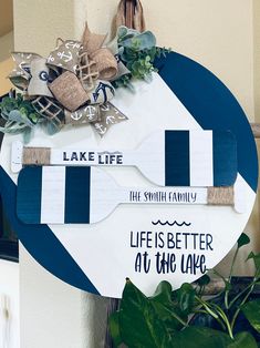 a life is better at the lake sign with burlocks and greenery on it