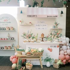 a table with some food on it and balloons in the air behind it that says penelope's