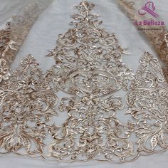 three pieces of silver metal lace on a white cloth with gold trimmings and an intricate design