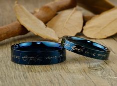 two blue rings with writing on them are sitting next to each other and some leaves