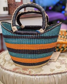 HandWoven in Ghana. This beautiful colourful crafted basket is made from Ghana using Wild Elephant grass ,goat hide, tinted natural plant dye that do not stain and expect craftsmanship. These baskets are ideal for storage, carriage or colourful decor. These baskets which are made from Bolga are known for their durability, quality and charm. Purchasing these baskets helps support farming families as weavers earns a sustainable income. Our Goal is not only to offer highest quality Bolga baskets,bu Blue Basket Straw Bag For Market, Multicolor Straw Bag With Braided Handles As Gift, Traditional Multicolor Bucket Straw Bag, Artisan Multicolor Bucket Straw Bag, Artisan Multicolor Basket Straw Bag, Artisan Multicolor Straw Bucket Bag, Multicolor Handwoven Bucket Straw Bag, Multicolor Basket Straw Bag For Market, Multicolor Bucket Straw Bag For Market