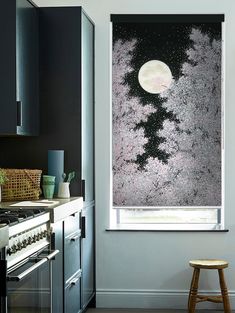 a kitchen with an oven, stove and window covered in frosty snow at night