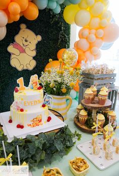 a winnie the pooh themed birthday party with cupcakes, cake and candy