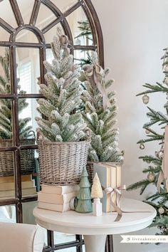 a christmas tree in a basket next to a table with books and other holiday decorations