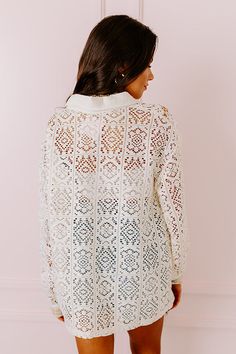 - Stay in a boho state of mind with this unique top! - Unlined crochet material featuring cream, white and ivory panels of different abstract patterns - Soft subtly textured accents - A collared - A button closure front - A functional chest pocket - Long sleeves with button closure cuffs featuring pink, blue, and purple hued accents with neutral hued sequins - A relaxed silhouette that ends in a straight hemline Cream Open Knit Lace Tops, Bohemian Lace Top With Lace Trim For Layering, Lace Crochet Top With Lace Trim For Layering, Cream Lace Top With Open Knit, Cream Lace Open Knit Top, White Bohemian Crochet Top With Lace Trim, White Crochet Top With Lace Collar, White Boho Collar Top For Beach, White Long Sleeve Top With Boho Collar