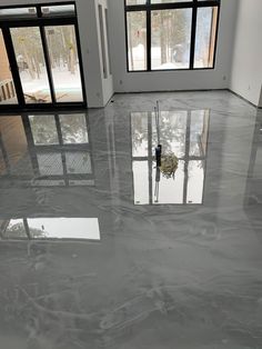 an empty room with large windows and marble flooring in the foreground, looking out onto a snowy landscape