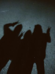 two people standing next to each other with their shadows on the ground in front of them